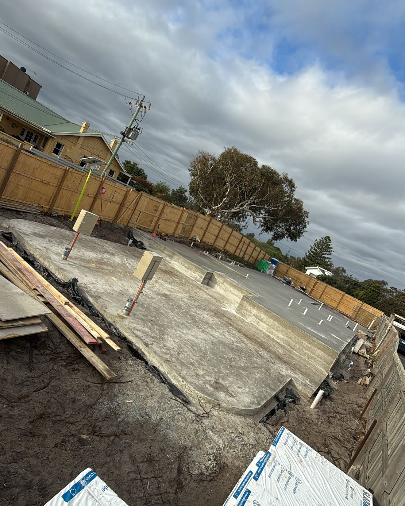 Concrete slab with timber formwork edges beside a timber fence
